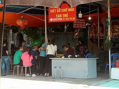 Nhân dân đi chơi 2/9 còn tìm về truyền thống. Hình ảnh viết sớ tán thẻ tại khu vực Đền Mẫu.